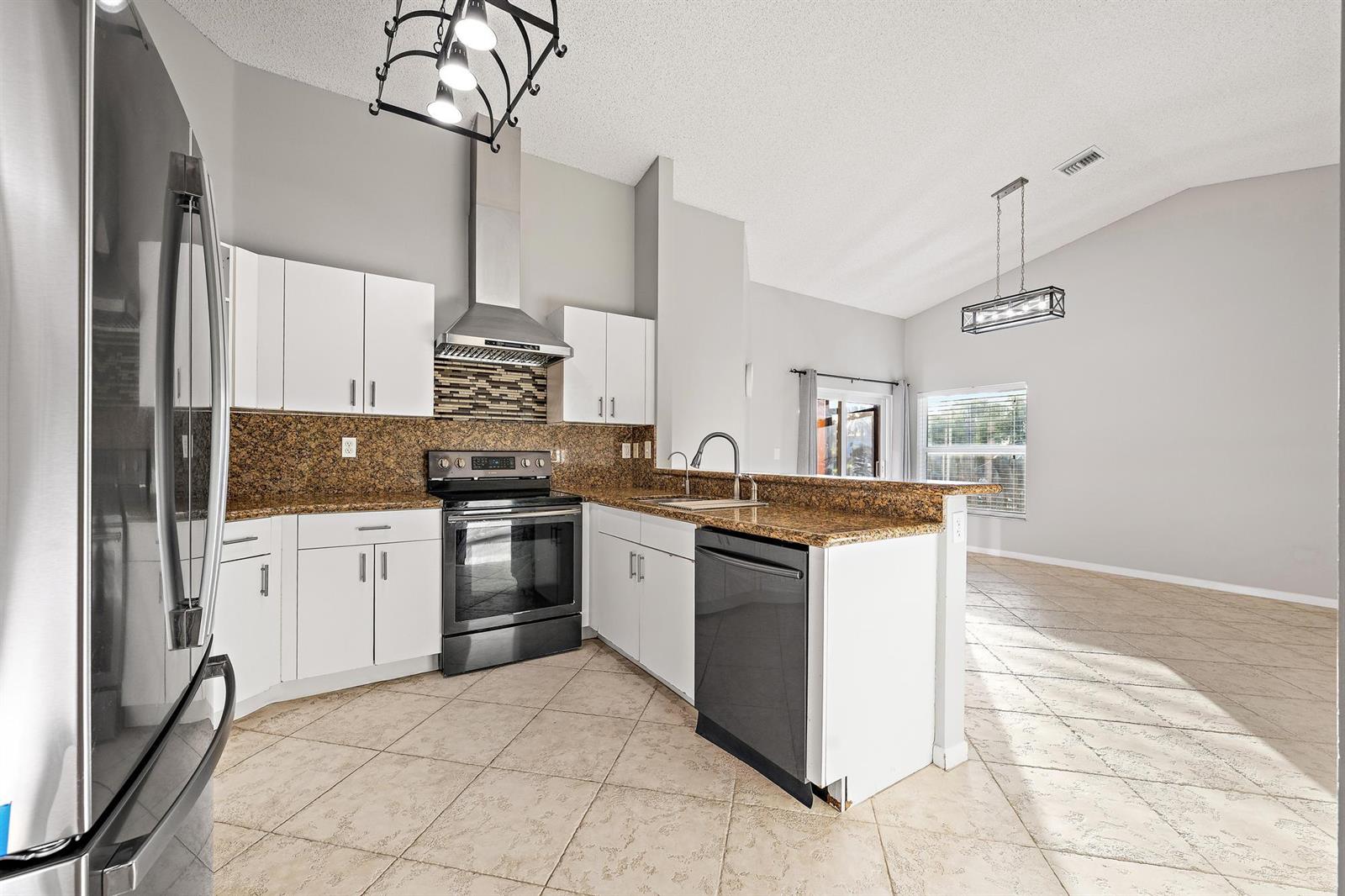A dining area and living space feature light blue walls, tile flooring, and mirrored walls — 8657 Tourmaline Boulevard, Boynton Beach FL 33472, BOYNTON BEACH, FL