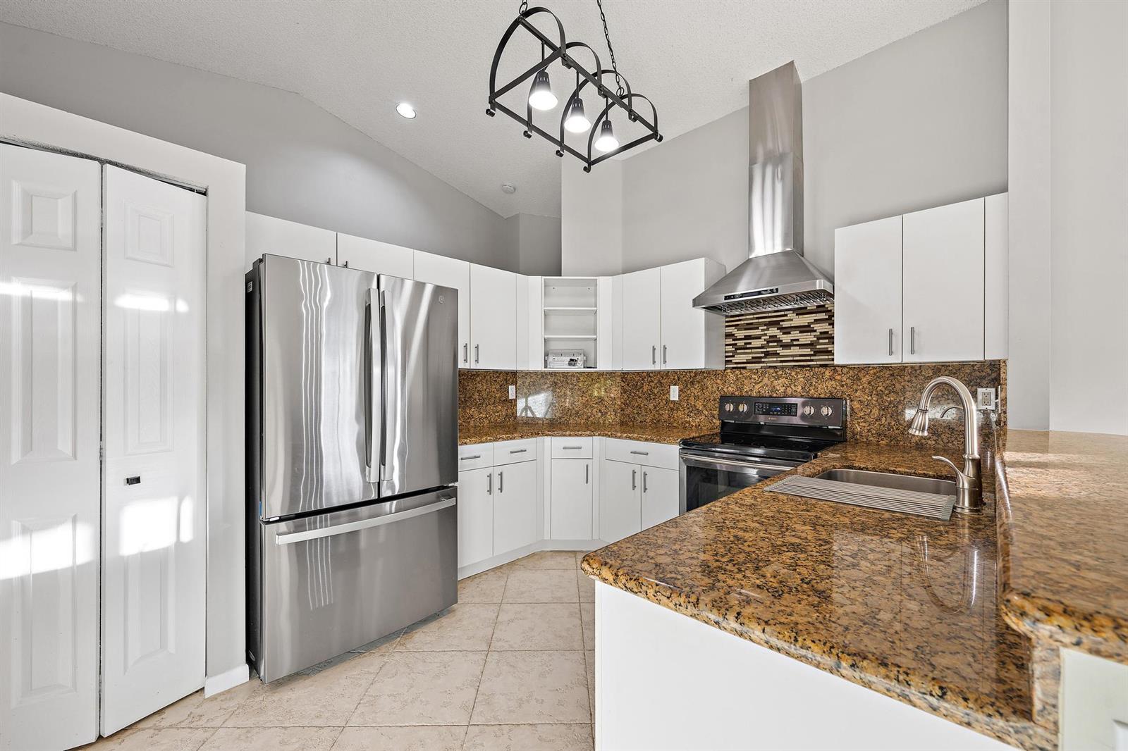 An empty room with light blue walls, tile flooring, and a large mirrored wall — 8657 Tourmaline Boulevard, Boynton Beach FL 33472, BOYNTON BEACH, FL