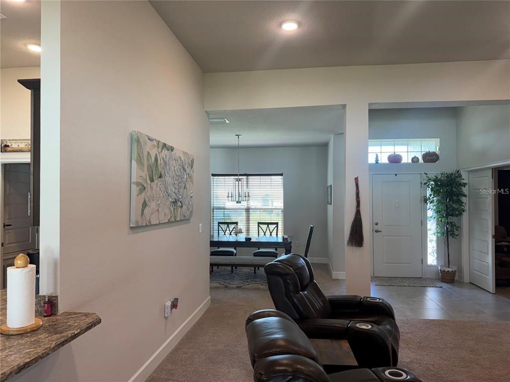 A view from a kitchen counter looking toward a dining area and front entryway — 5123 SW 91ST STREET, OCALA, FL