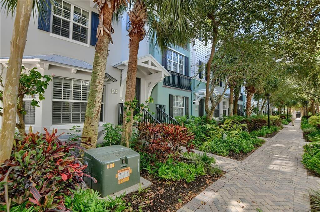 A row of multi-story townhouses with landscaped front gardens and a brick pedestrian walkway — 306 E Mallory Circle, Delray Beach FL 33483, DELRAY BEACH, FL