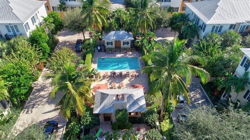 An aerial view shows a swimming pool surrounded by palm trees and residential buildings — 306 E Mallory Circle, Delray Beach FL 33483, DELRAY BEACH, FL