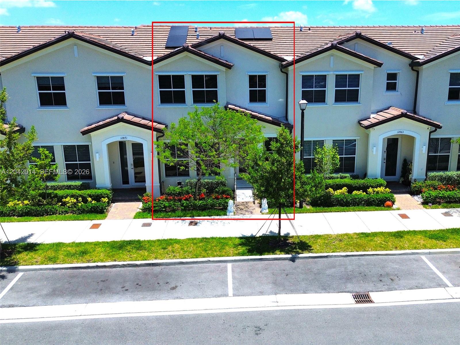 An exterior view of a two-story townhouse with a red-tiled roof and solar panels — 12867 SW 243rd Ter, Homestead FL 33032, HOMESTEAD, FL