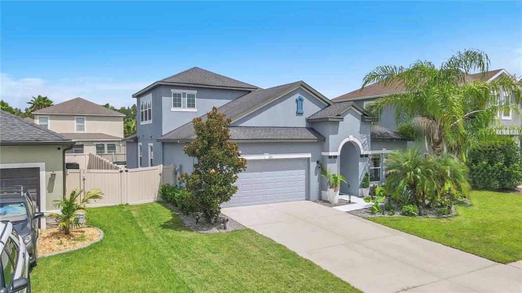 A two-story gray house with a two-car garage, a concrete driveway, and a manicured lawn — 1571 MONTGOMERY BELL RD, WESLEY CHAPEL, FL