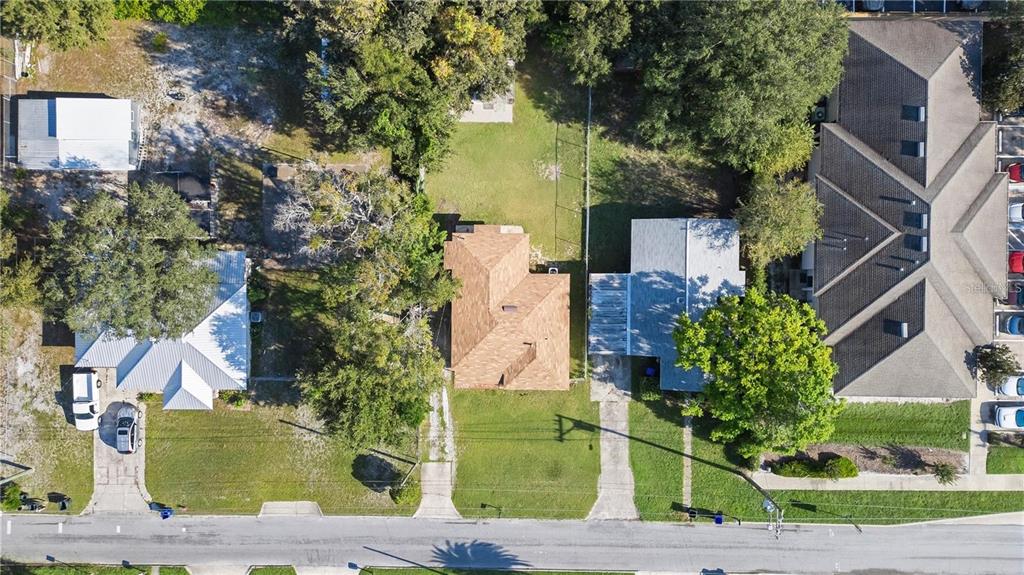 An aerial view shows three residential properties with driveways, trees, and lawns along a street — 402 TUSCARORA STREET, LAKELAND, FL