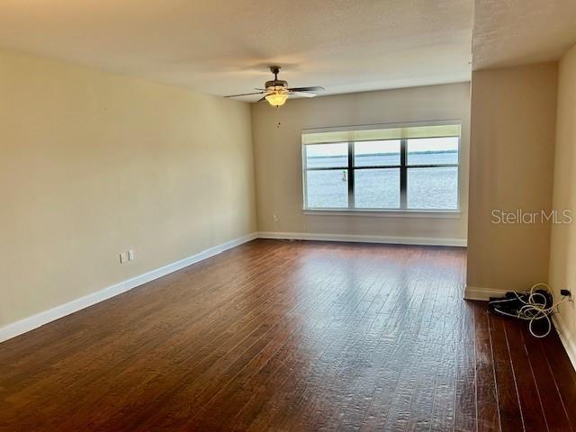 An empty room with dark wood flooring, a ceiling fan, and a large window overlooking water — 225 W SEMINOLE BOULEVARD UNIT 308, SANFORD, FL