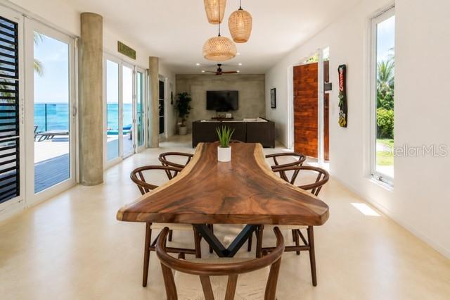 A dining room features a live-edge wood table, modern pendant lights, and ocean views — 14 CAMINO LAS PICUAS, RIO GRANDE, PR