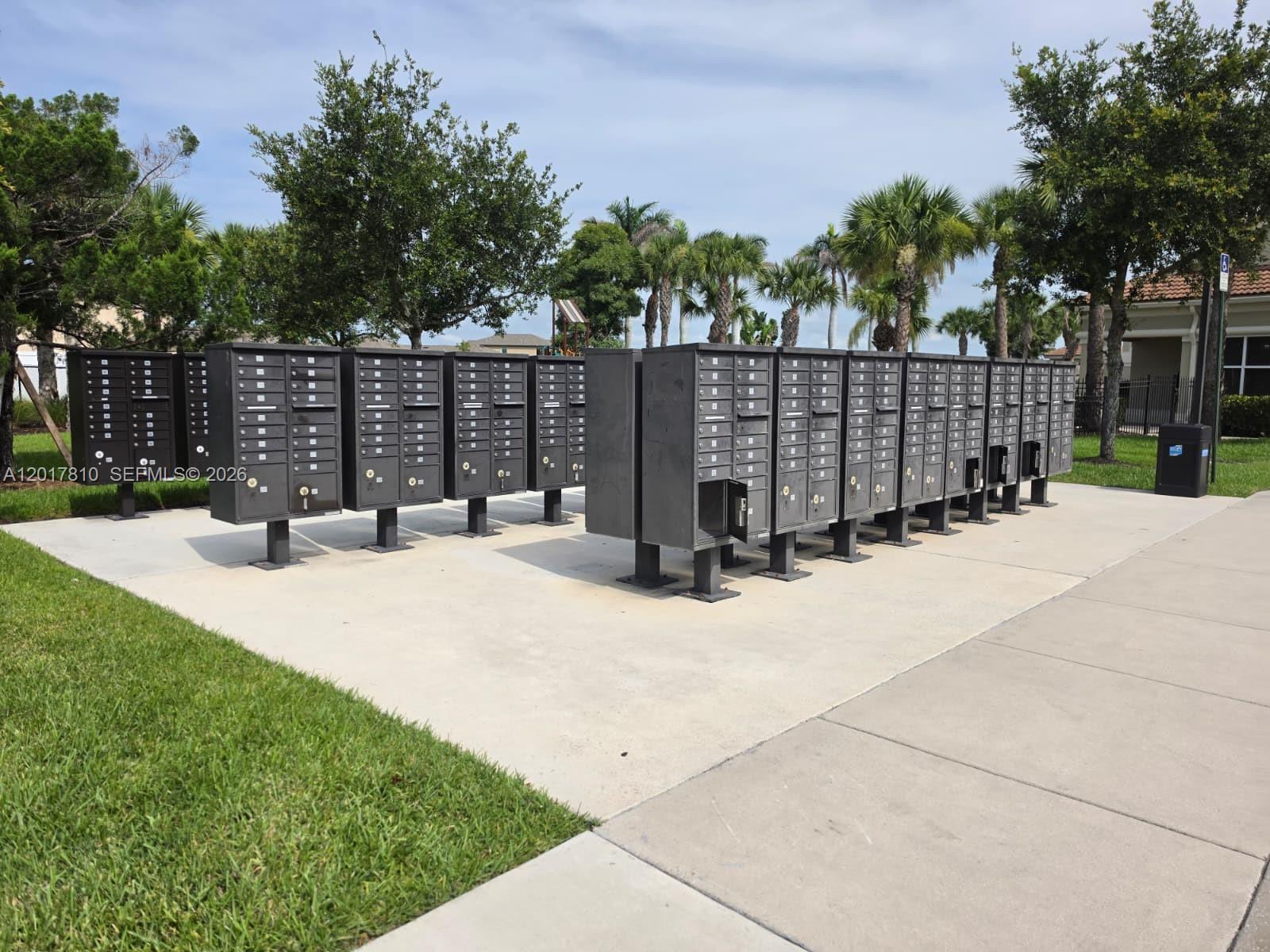 A row of outdoor metal mailboxes stands on a concrete pad near trees — 831 Bent Creek Dr, Fort Pierce FL 34947, FORT PIERCE, FL
