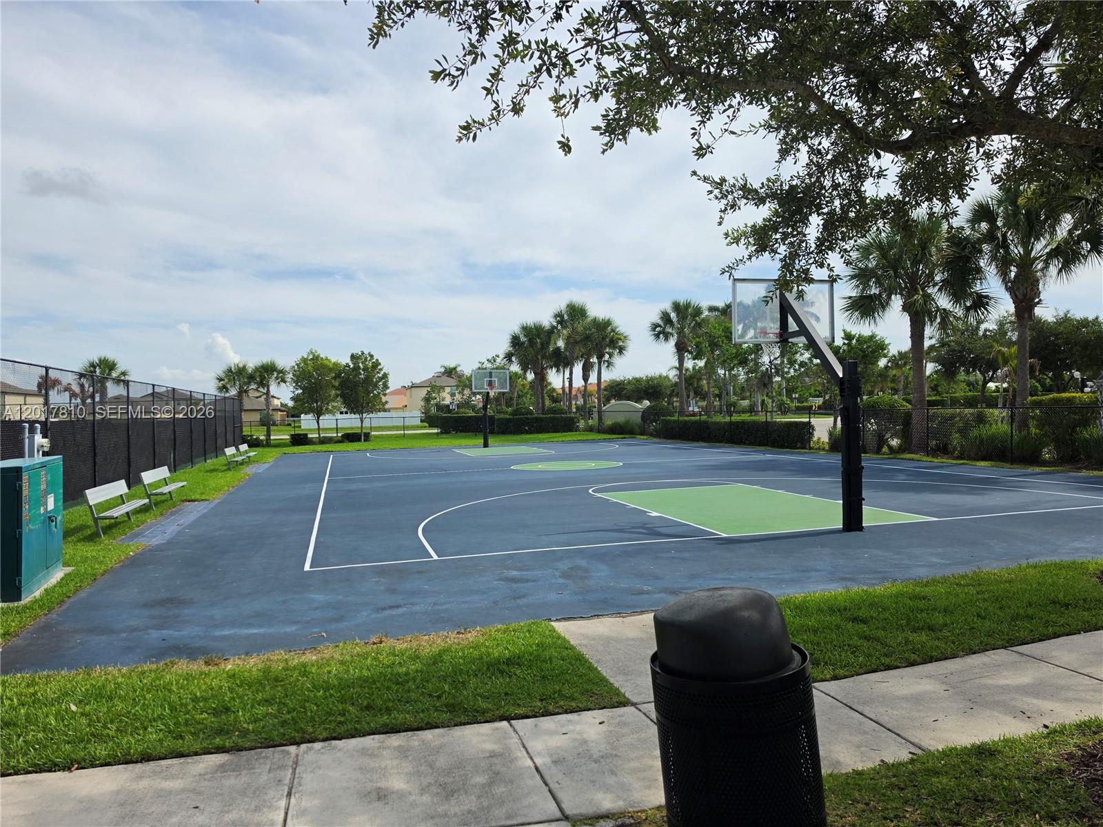 An outdoor basketball court features a blue and green surface with two hoops and benches — 831 Bent Creek Dr, Fort Pierce FL 34947, FORT PIERCE, FL
