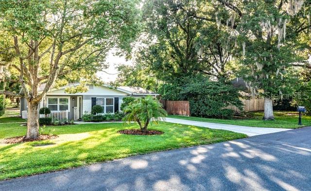 A single-story house with a white and gray exterior sits behind a concrete driveway — 5725 14TH STREET, ZEPHYRHILLS, FL