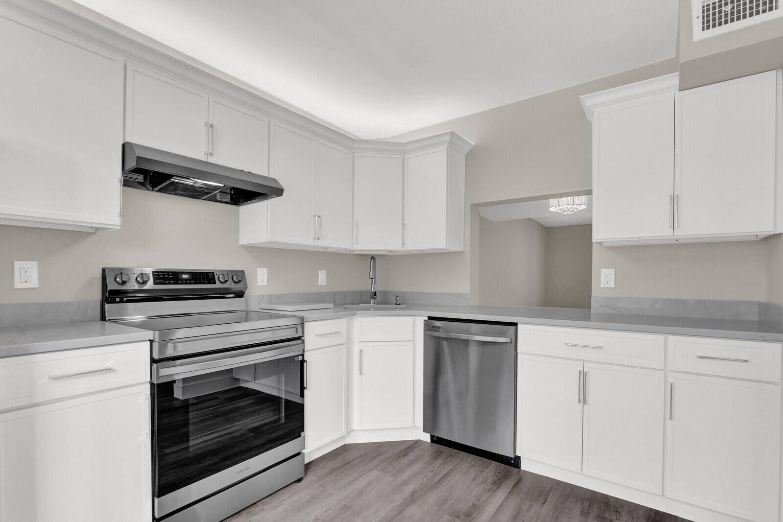 A kitchen with white cabinets, stainless steel appliances, and gray countertops — 234 Foxtail Drive, FL 33415, FL