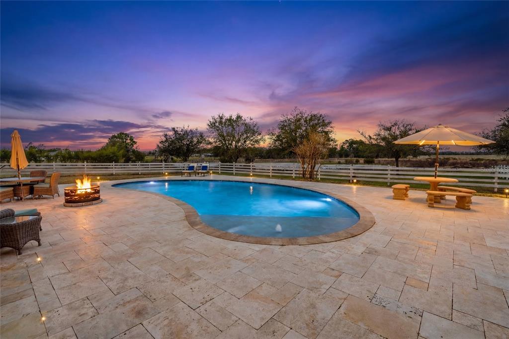 A large Mediterranean-style house with a covered walkway and lawn at sunset — 4015 INDIGO ROAD, GROVELAND, FL