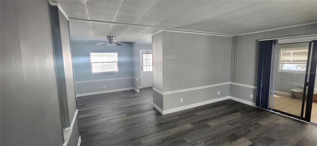 A living room features gray walls, white chair rail molding, and dark wood-look flooring — 10803 FREEDOM DRIVE, PORT RICHEY, FL