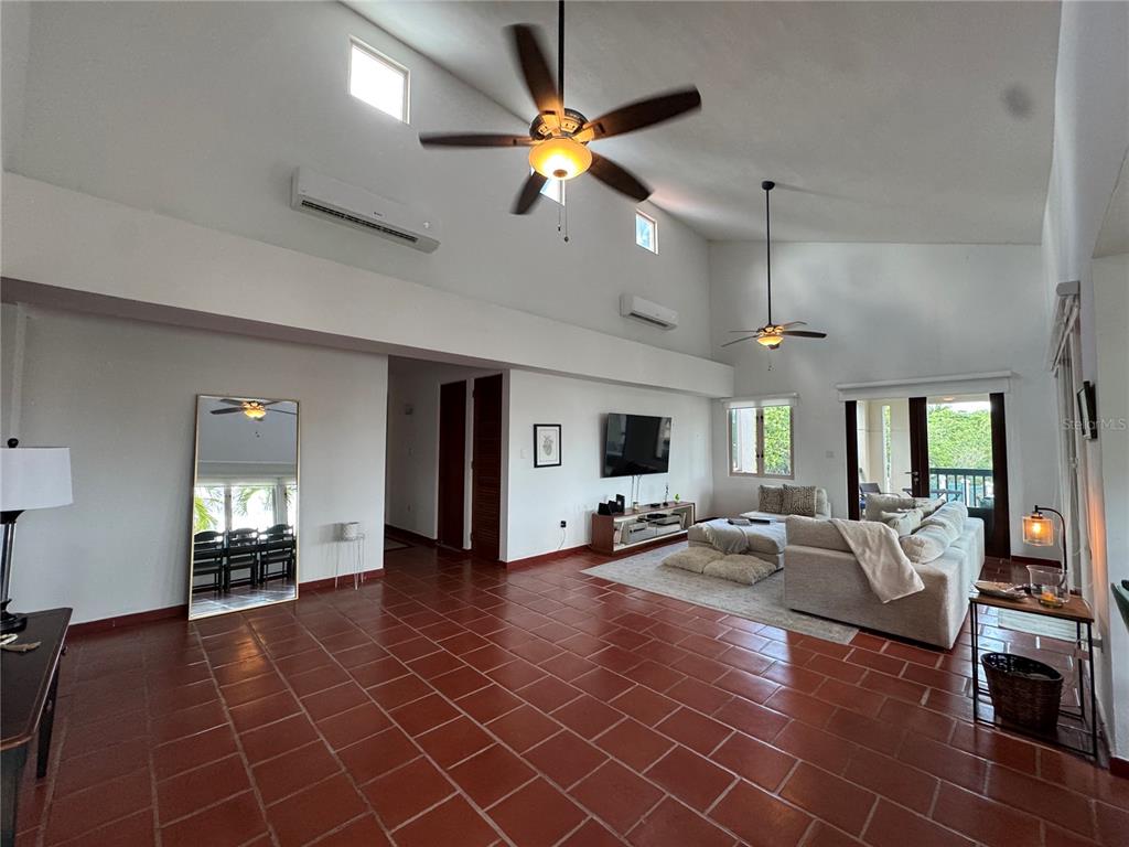 A spacious living room features vaulted ceilings, terracotta tile floors, and a large sectional sofa — 86 LAKESIDE VILLAS UNIT F2, VEGA ALTA, PR