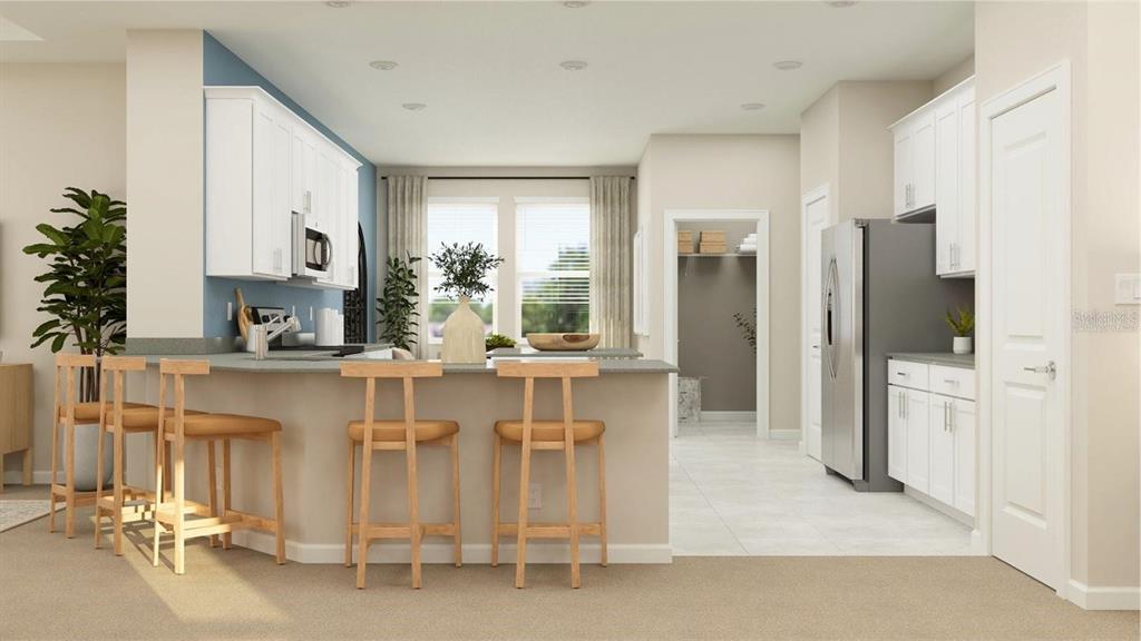 This is a digital rendering of a kitchen with white cabinets, a breakfast bar, and appliances — 2155 RIDER RAIN LANE, APOPKA, FL