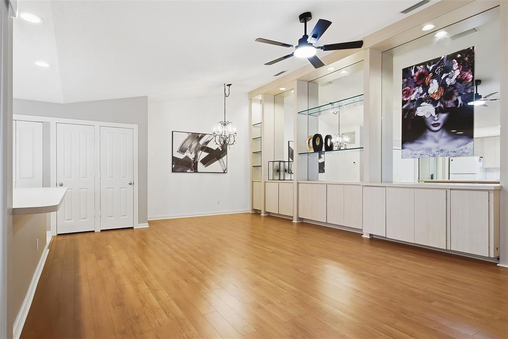 A dining room features light wood flooring, a chandelier, and a large built-in display cabinet — 9502 CHAPMAN OAK COURT, PALM BEACH GARDENS, FL