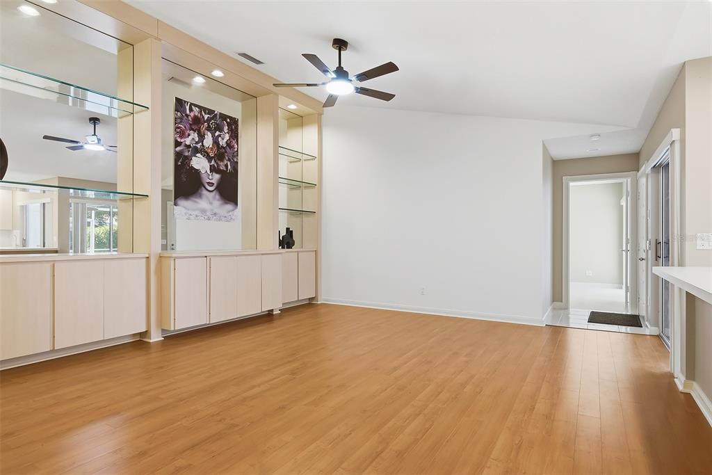 A room with light wood flooring, built-in shelving, a ceiling fan, and a doorway — 9502 CHAPMAN OAK COURT, PALM BEACH GARDENS, FL