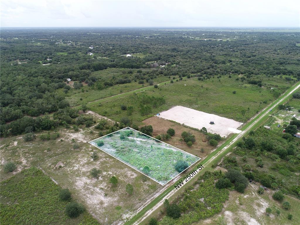 An aerial view shows a rectangular plot of land bordered by a dirt road — 18235 NW 250TH STREET, OKEECHOBEE, FL