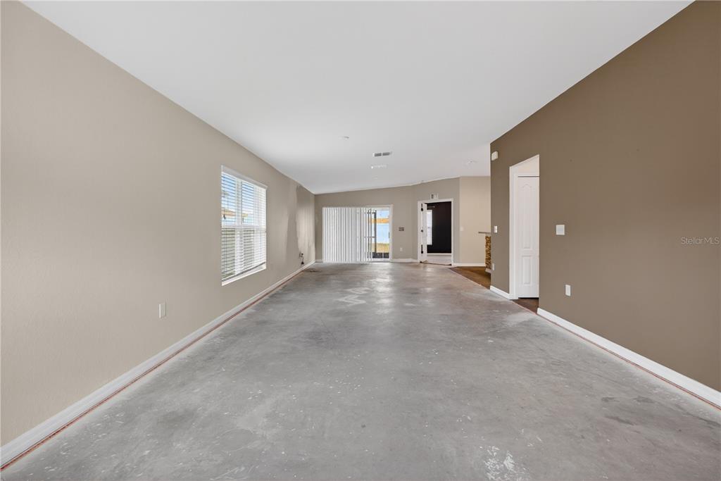 An empty room with concrete flooring, two-toned walls, and a sliding glass door — 1919 THOMPSON PRESERVE BOULEVARD, BARTOW, FL