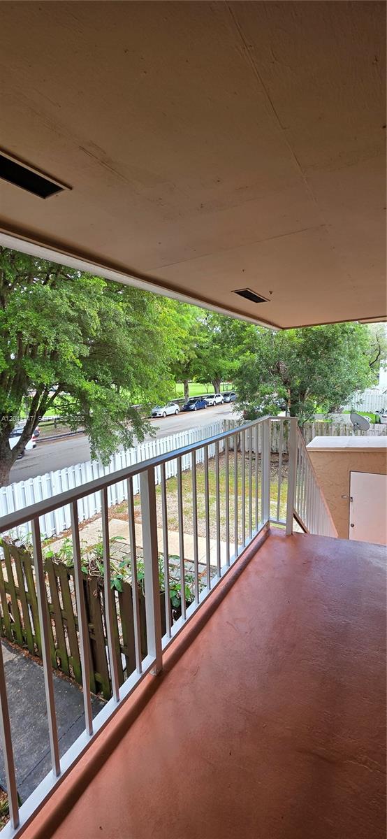 A covered balcony overlooks a street with parked cars and a white picket fence — 8480 SW 154th Cir Ct # 925, Miami FL 33193, MIAMI, FL