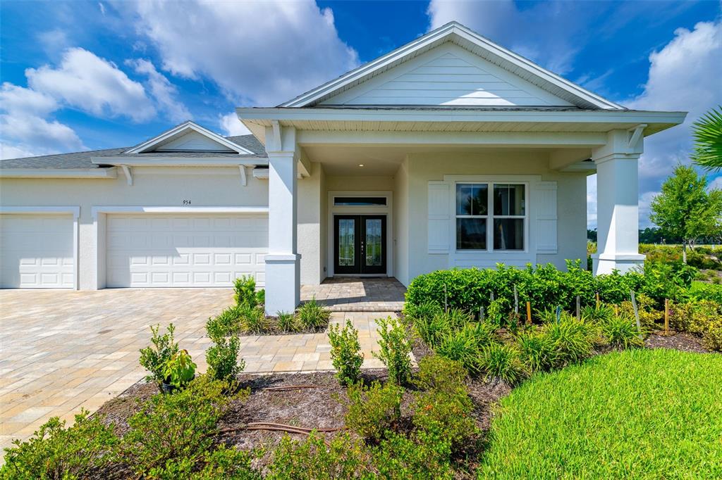A single-story house with a beige stucco exterior, a covered entryway, and a multi-car garage — 954 MEGANO BOULEVARD, DELAND, FL