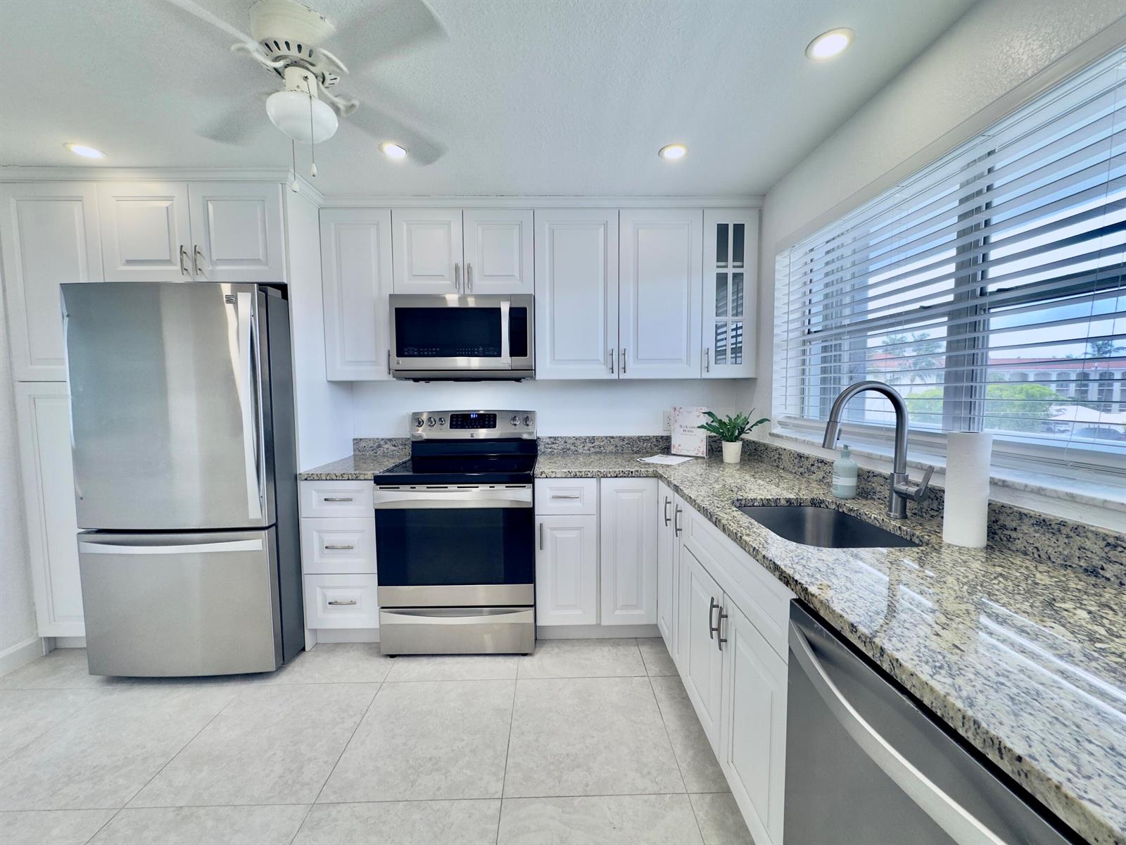 A kitchen with white cabinets, stainless steel appliances, and granite countertops — 2016 S Federal Highway # 404, Boynton Beach FL 33435, BOYNTON BEACH, FL