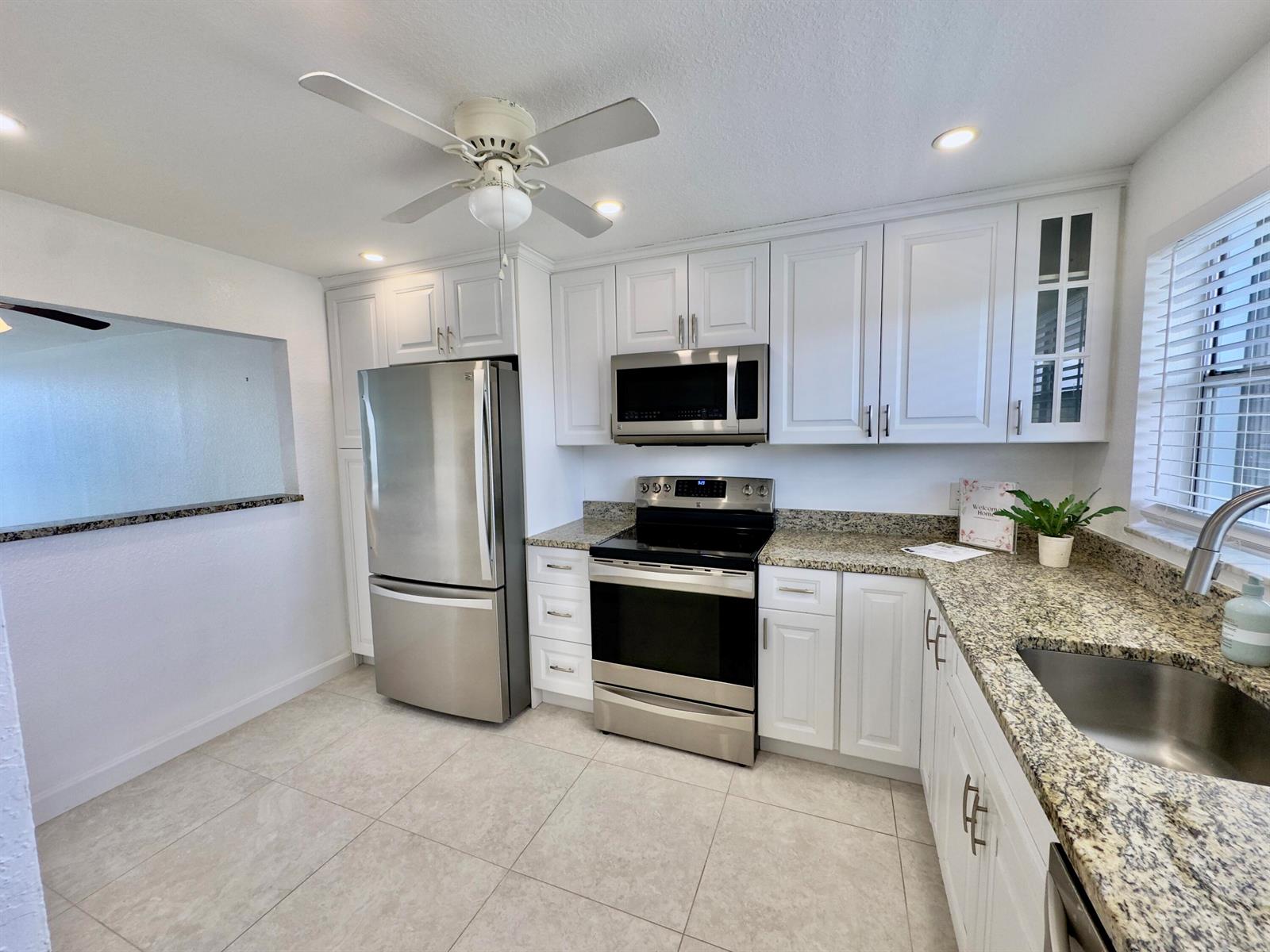 A kitchen with white cabinets, stainless steel appliances, and granite countertops — 2016 S Federal Highway # 404, Boynton Beach FL 33435, BOYNTON BEACH, FL