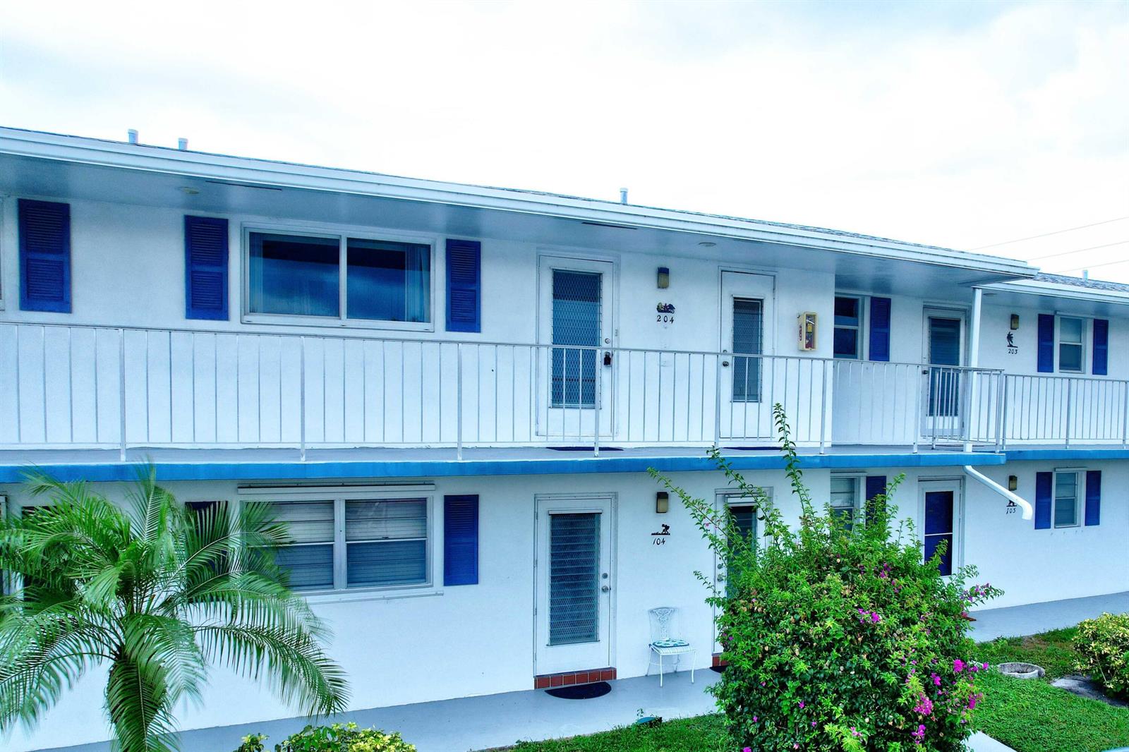 A two-story apartment building with white walls, blue shutters, and an exterior metal walkway — 1118 Lake Terrace # 204, Boynton Beach FL 33426, BOYNTON BEACH, FL
