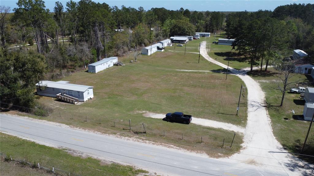 An aerial view shows a mobile home park with several trailers situated on a grassy lot — 16790 82ND PLACE, LIVE OAK, FL