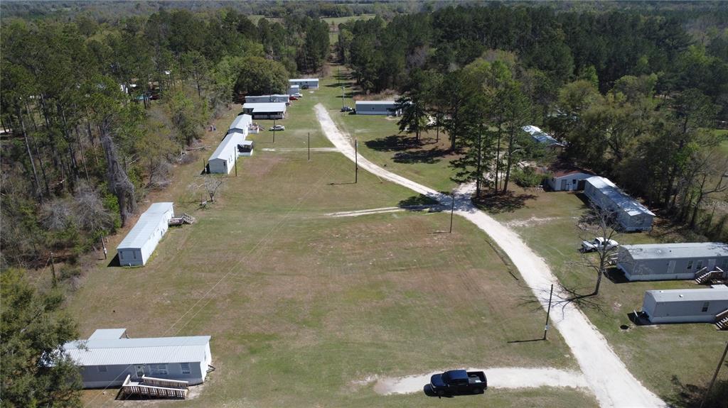 An aerial view shows a rural mobile home park with several trailers situated on a grassy lot — 16790 82ND PLACE, LIVE OAK, FL