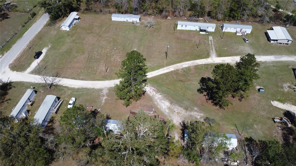 An aerial view shows several mobile homes situated on a large, grassy, wooded lot — 16790 82ND PLACE, LIVE OAK, FL