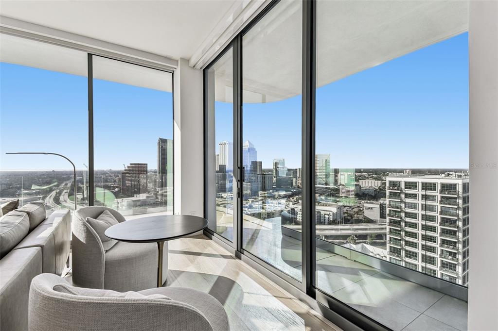 A modern living room features floor-to-ceiling windows with a panoramic view of a city skyline — 1000 WATER STREET UNIT 2202, TAMPA, FL