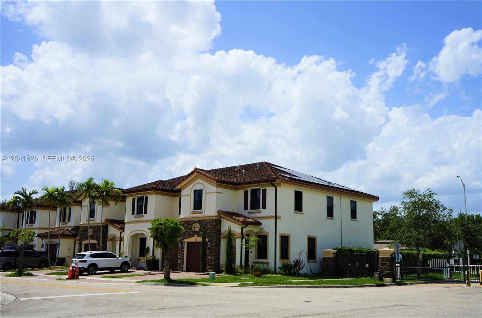 A two-story residential building with a tiled roof and stone accents sits on a corner — 3365 W 91st Ter # 3365, Hialeah FL 33018, HIALEAH, FL
