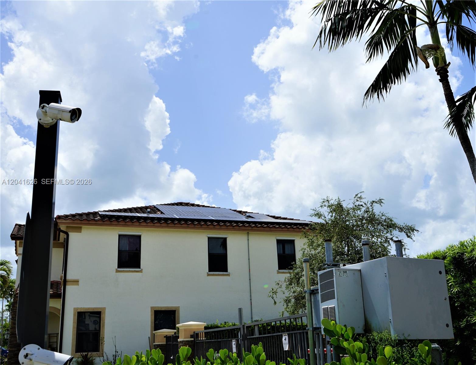 A two-story building features solar panels on the roof, a security camera, and exterior equipment — 3365 W 91st Ter # 3365, Hialeah FL 33018, HIALEAH, FL