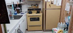 A small kitchen features yellow appliances, a stainless steel sink, and white cabinetry — 86 Westbury # 86, Deerfield Beach FL 33442, DEERFIELD BEACH, FL