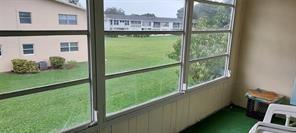 A view from a screened-in porch looking out over a grassy lawn and apartment buildings — 86 Westbury # 86, Deerfield Beach FL 33442, DEERFIELD BEACH, FL