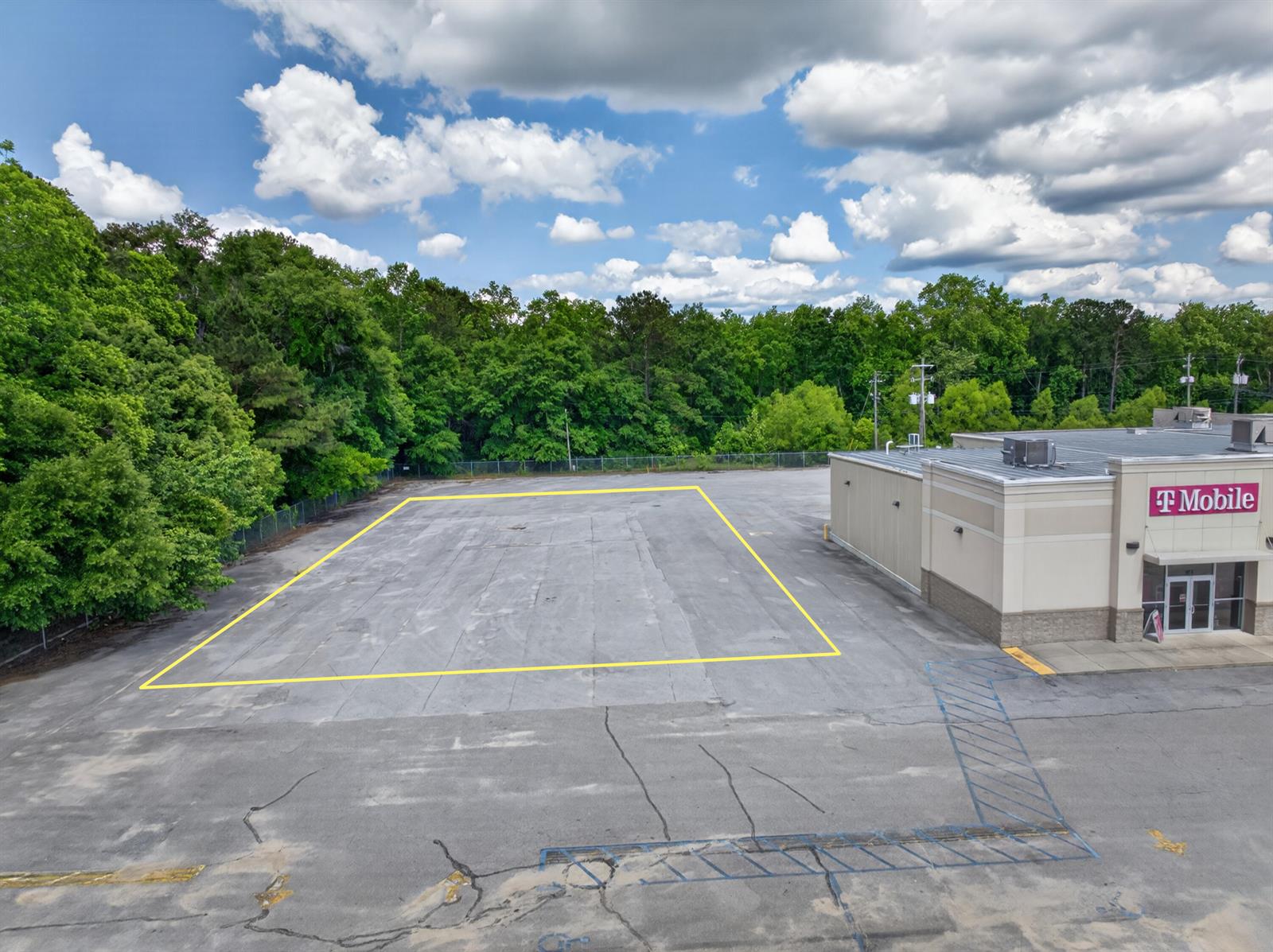 An aerial view shows a paved parking lot with a yellow-outlined area beside a building — 0 South Drive, FL 32433, FL