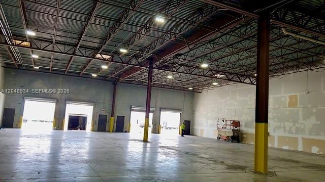 An expansive, open warehouse interior features high ceilings, exposed steel trusses, and multiple loading docks — 11701 NW 102nd Rd # 10, Medley FL 33178, MEDLEY, FL