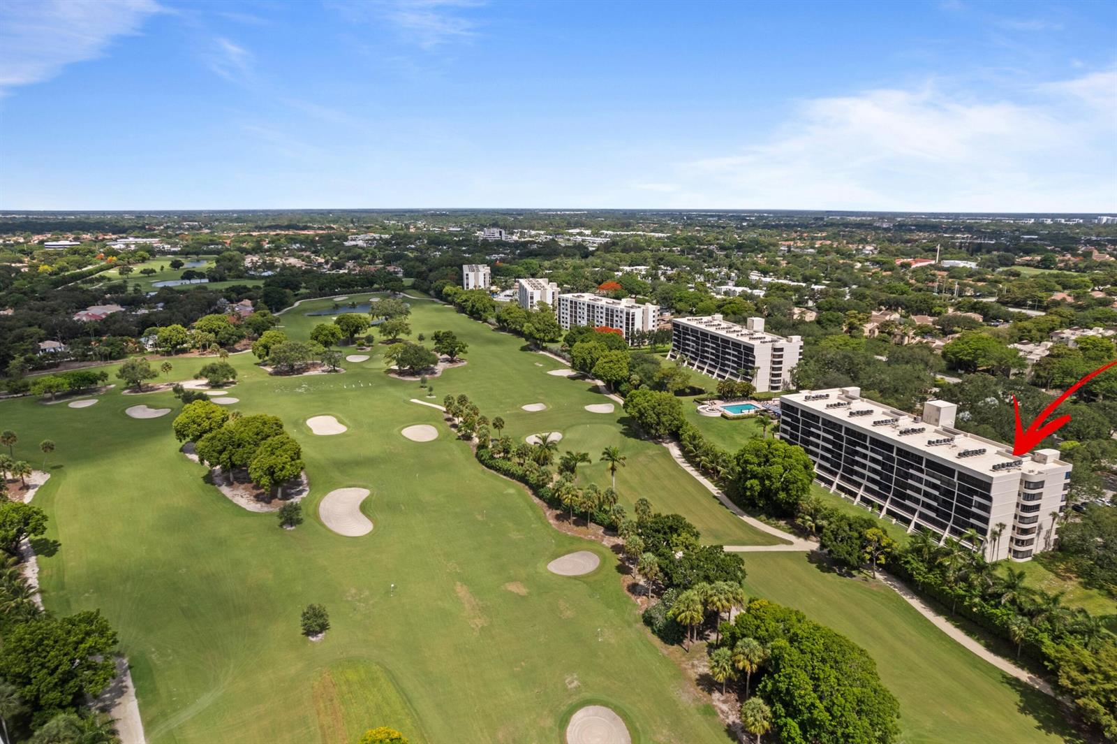 An aerial view shows a multi-story apartment building situated next to a large golf course — 6420 Boca Del Mar Drive # 601, Boca Raton FL 33433, BOCA RATON, FL
