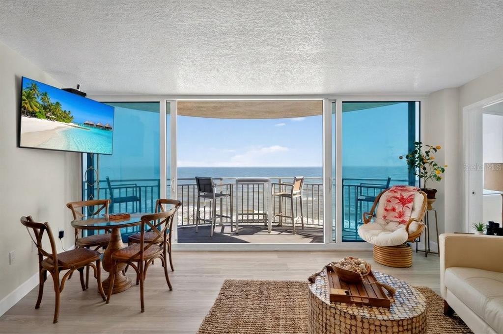 A living and dining area features floor-to-ceiling windows with an ocean view and balcony access — 2625 S ATLANTIC AVENUE UNIT 14NE, DAYTONA BEACH, FL
