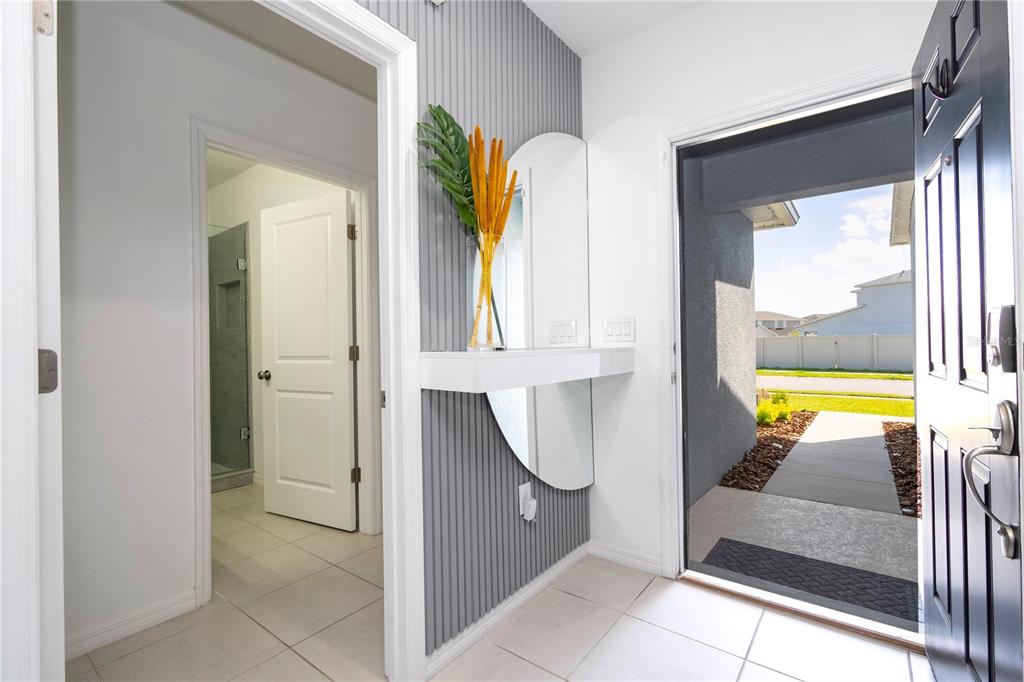 An entryway features a gray slatted accent wall, a floating shelf, and a mirror — 5166 TUSCANY LANE, DAVENPORT, FL