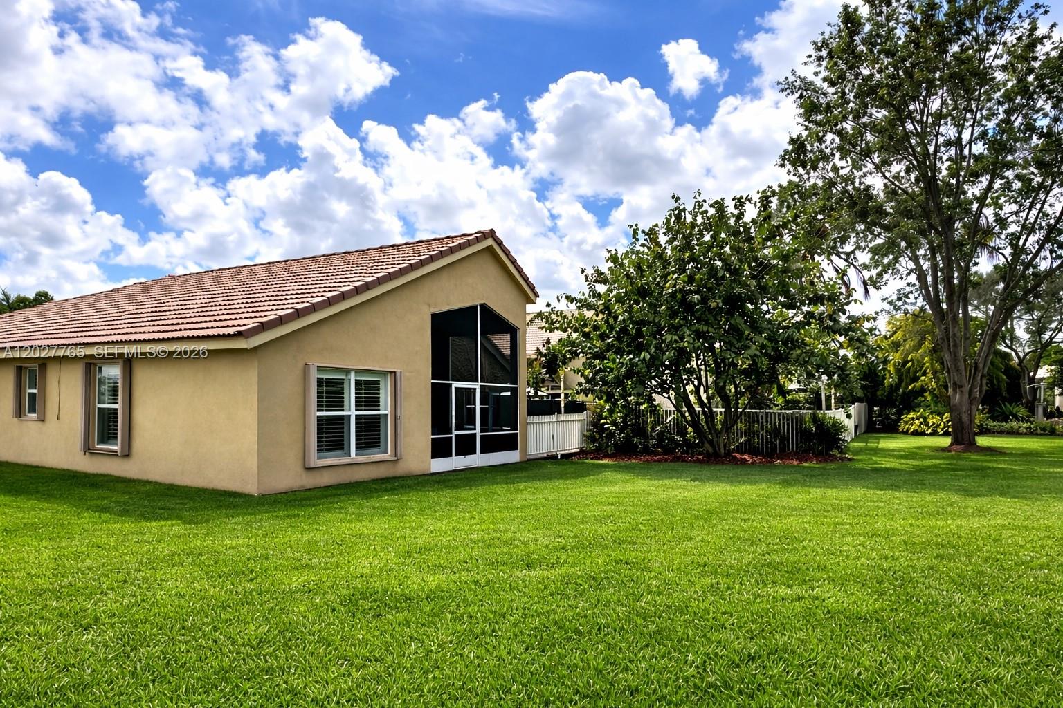 The exterior of a tan house with a tiled roof and a screened-in patio — 3933 Diamond Palladium Ter, Boynton Beach FL 33436, BOYNTON BEACH, FL