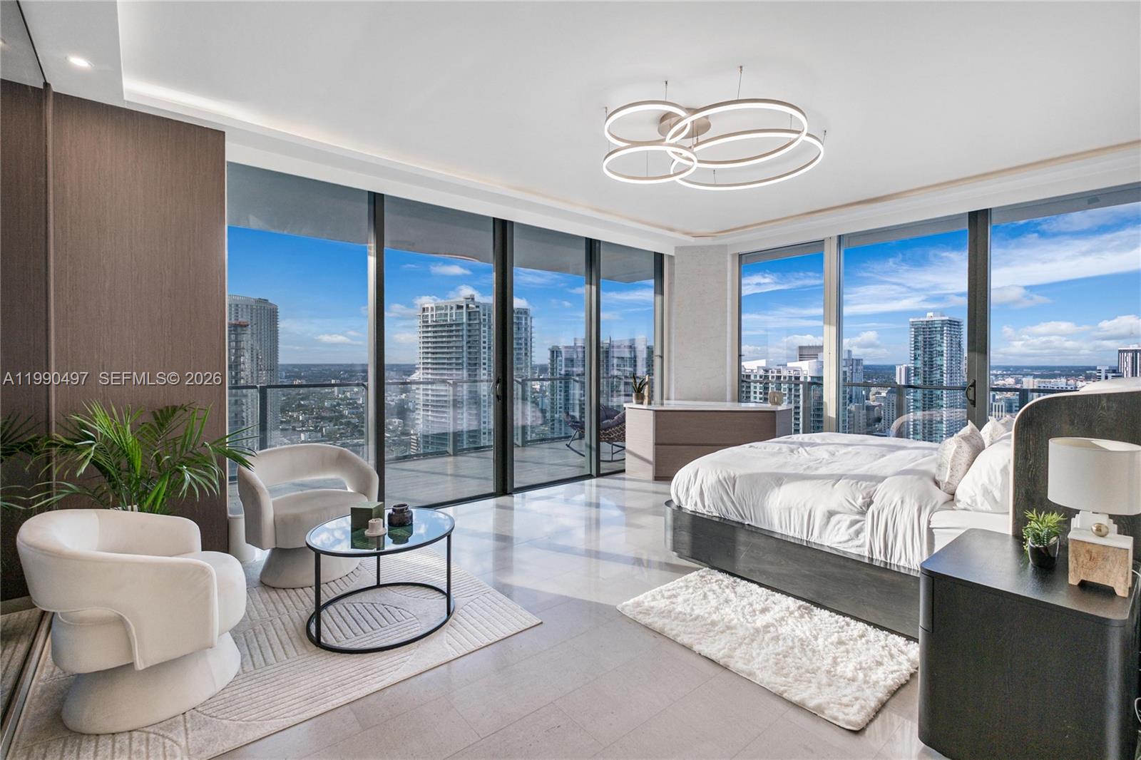 A modern bedroom features floor-to-ceiling windows, a platform bed, and a seating area — 68 SE 6th St # 3711, Miami FL 33131, MIAMI, FL