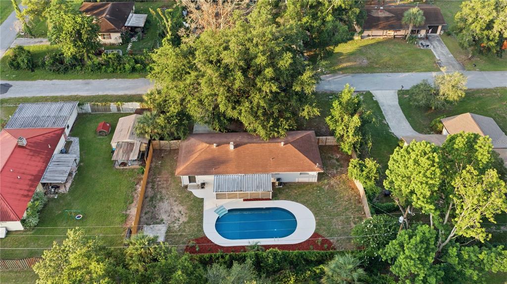 An aerial view shows a single-story house with a backyard pool and a large tree — 5611 NE 5TH PLACE, OCALA, FL