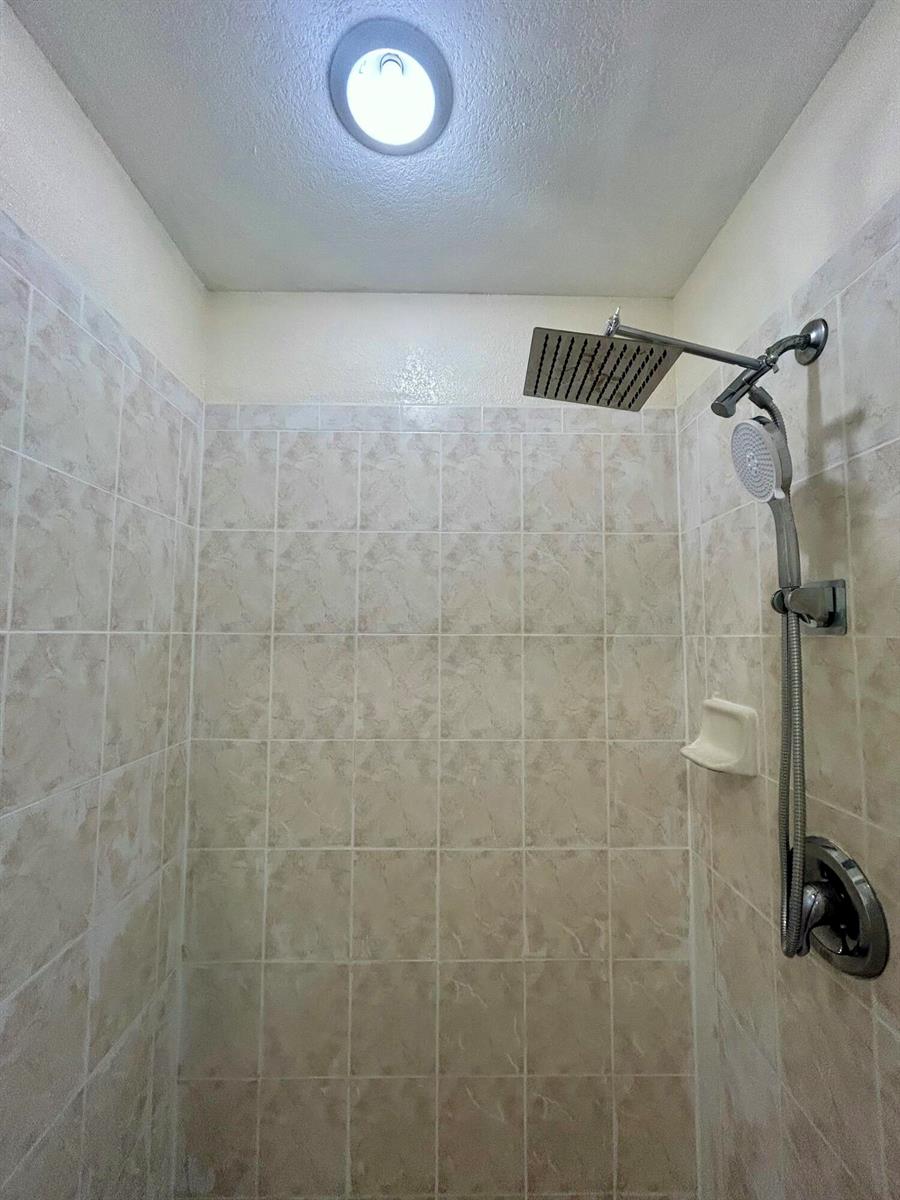 A tiled shower stall features a dual-head shower system and a recessed ceiling light — 328 W Sugarland Circle, Clewiston FL 33440, CLEWISTON, FL