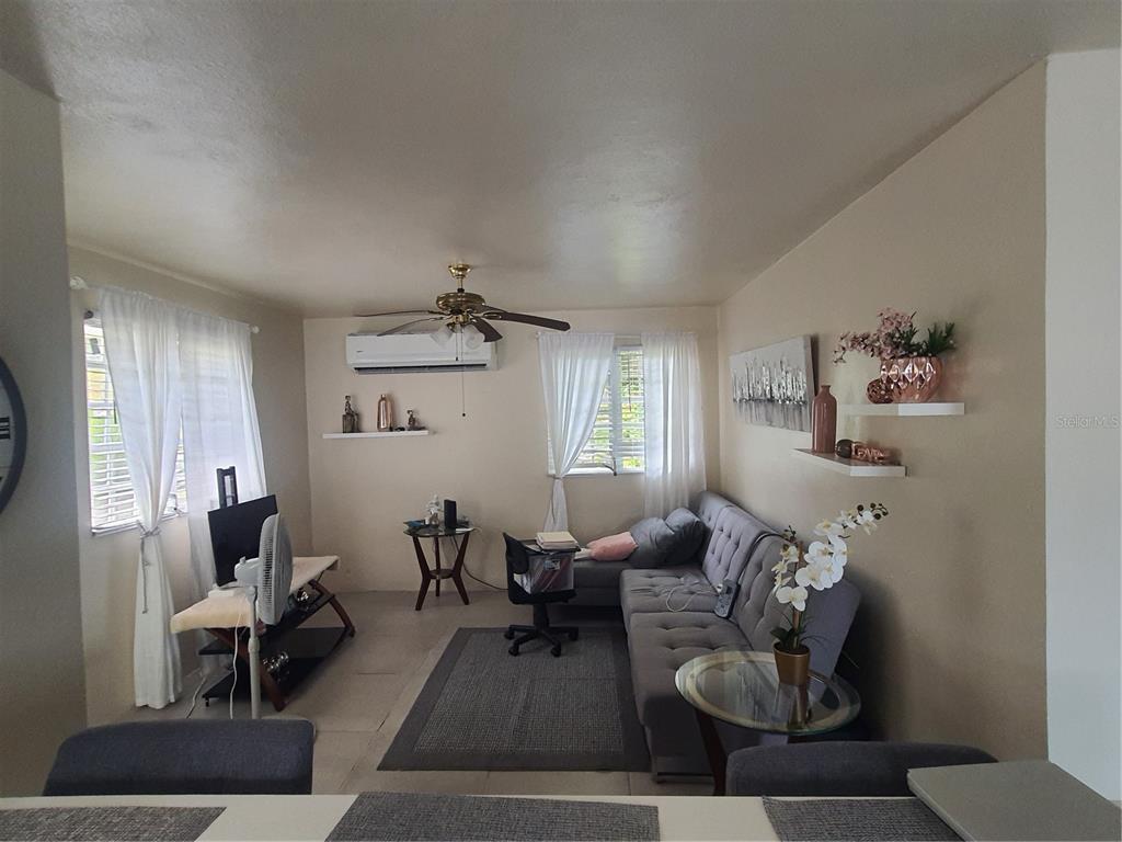 A living room features a gray sectional sofa, a ceiling fan, and white curtains — 2-A RIO CANAS WARD, LA BARRA COMMUNITY LOT 199, CAGUAS, PR