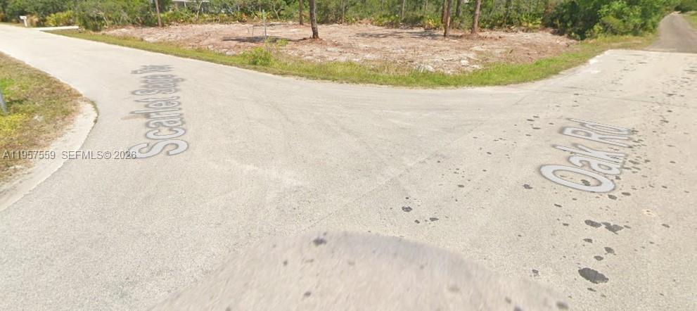 An intersection of two paved roads, Scarlet Sage Ter and Oak Rd, bordering a vacant lot — 1981 SCARLET SAGE TER, Sebring FL 33875, SEBRING, FL
