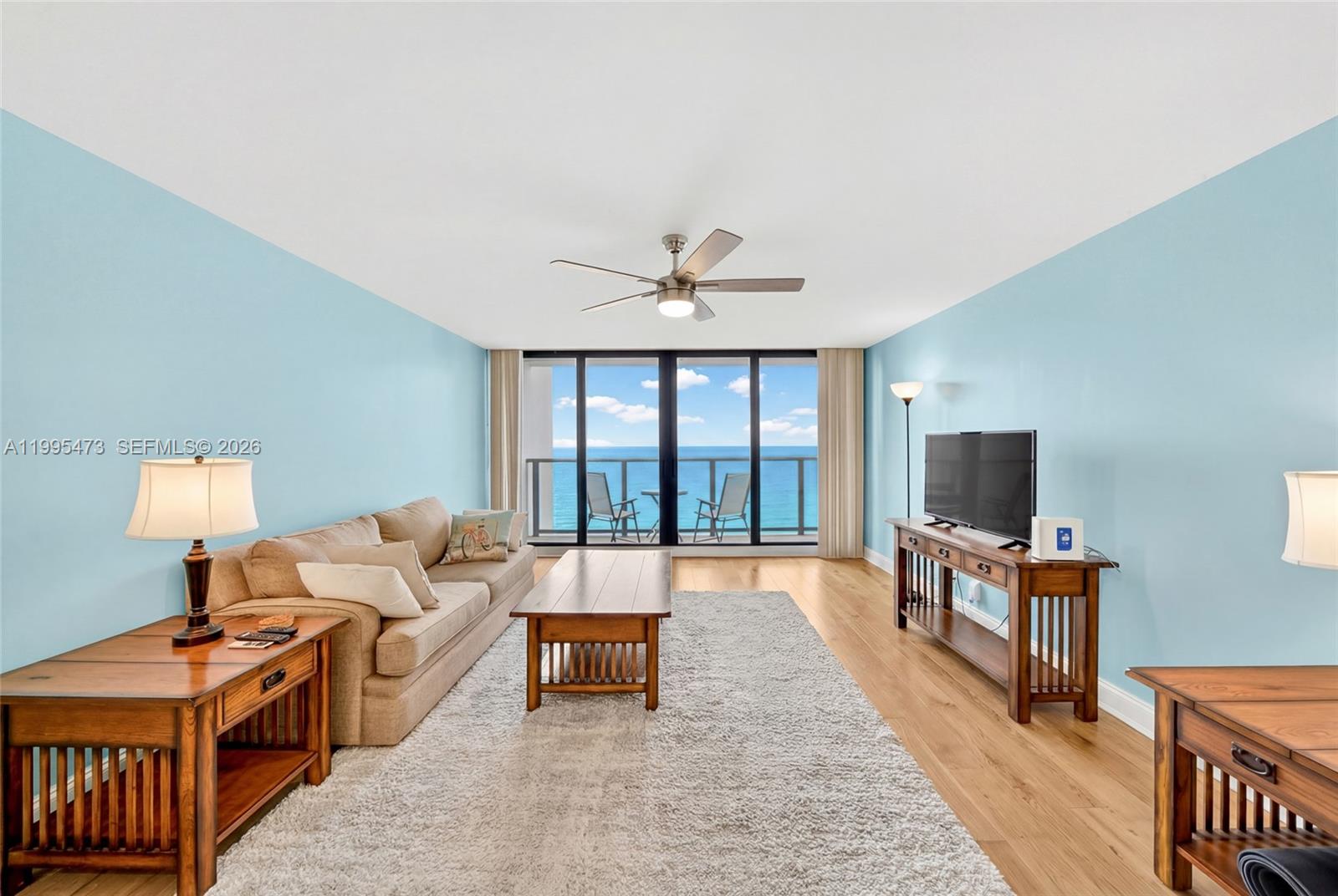 A living room features light blue walls, hardwood floors, a beige sofa, and ocean views — 2301 S Ocean Dr # 2302, Hollywood FL 33019, HOLLYWOOD, FL