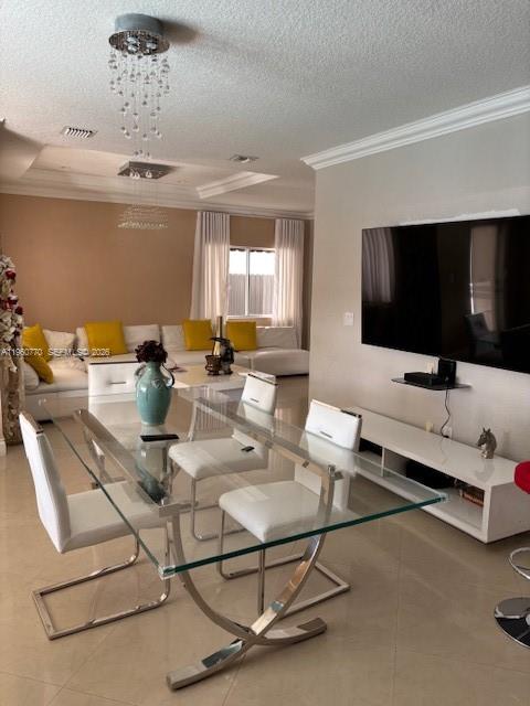 A dining area with a glass table and white chairs sits before a living room — 1710 SW 154th Path, Miami FL 33185, MIAMI, FL