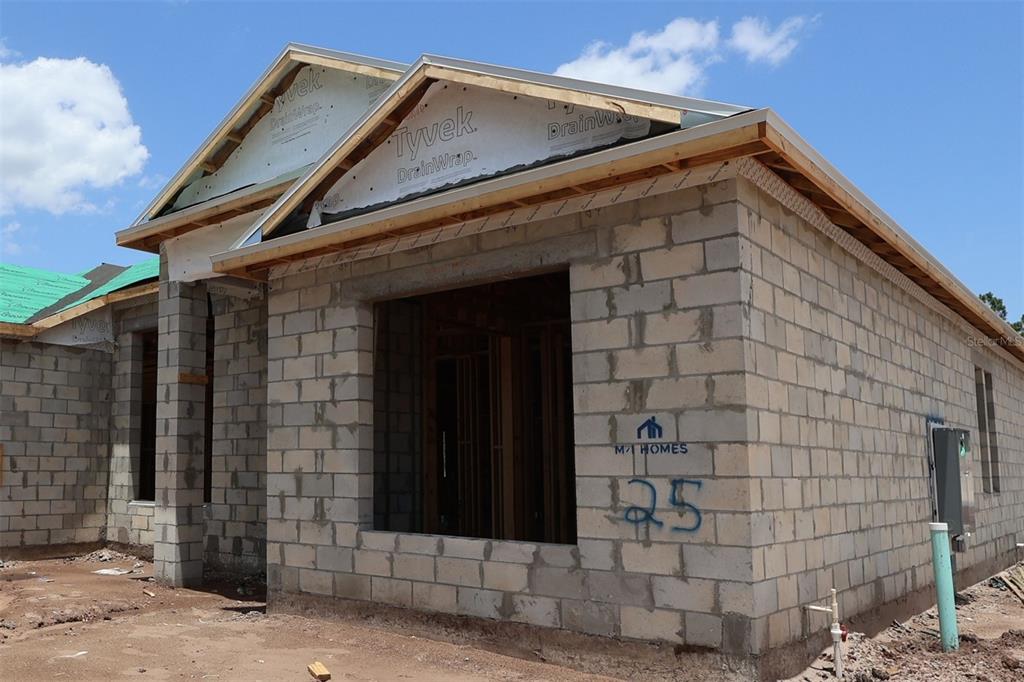 An exterior view of a house under construction featuring concrete block walls and roof framing — 3011 SOLACE WAY, ORLANDO, FL