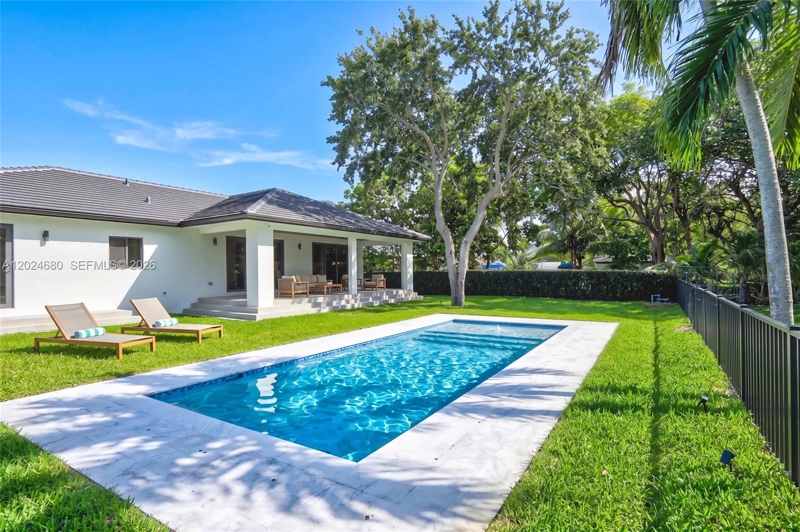 A backyard features a rectangular swimming pool, two lounge chairs, and a covered patio area — 6853 S Waterway Dr, Miami FL 33155, MIAMI, FL